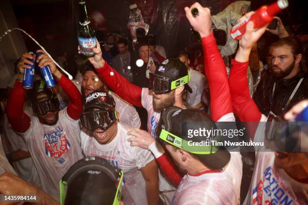 Bryce Harper of the Philadelphia Phillies celebrates with his teammates in the locker room after defeating the San Diego Padres in game five to win...