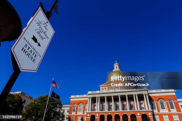 the freedom trail sign and the massachusetts state house - massachusetts capitol - boston massachusetts - massachusetts flag stock pictures, royalty-free photos & images