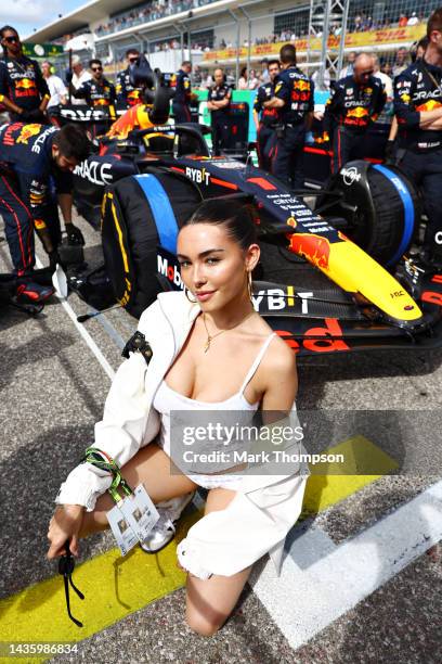 Madison Beer poses for a photo with the car of Max Verstappen of the Netherlands and Oracle Red Bull Racing on the grid during the F1 Grand Prix of...