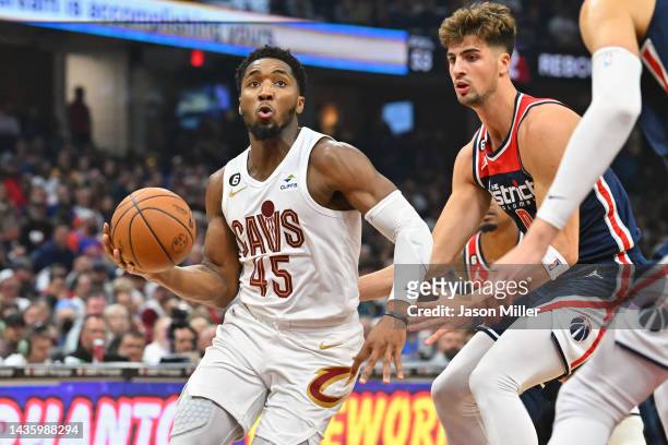 Donovan Mitchell of the Cleveland Cavaliers drives to the basket around Deni Avdija of the Washington Wizards during the second quarter at Rocket...
