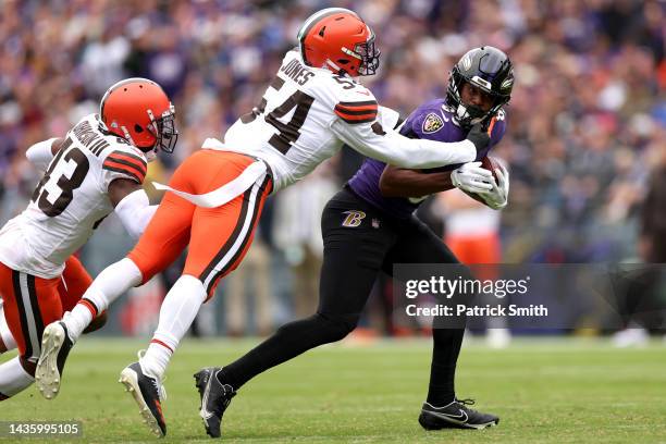 Lamar Jackson of the Baltimore Ravens looks to avoid a tackle by Deion Jones of the Cleveland Browns during the second half at M&T Bank Stadium on...