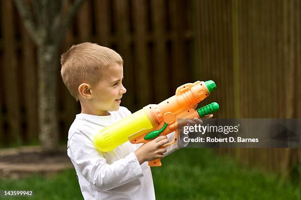 boy holding water gun - alleen jongens stockfoto's en -beelden