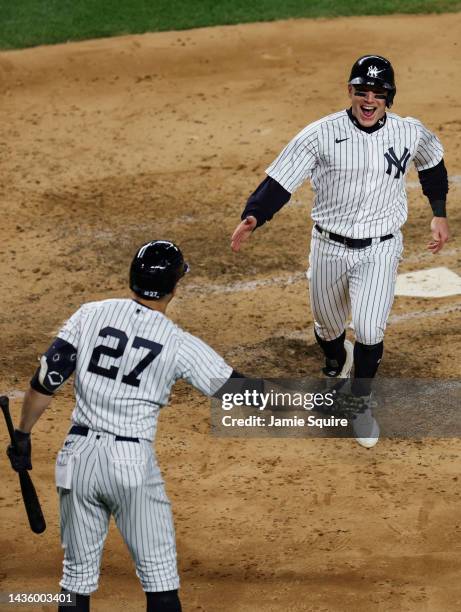 Harrison Bader of the New York Yankees celebrates scoring with Giancarlo Stanton during the fourth inning against the Houston Astros in game four of...