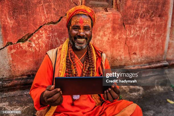 sadhu - indian holyman using digital tablet - temple body part stock pictures, royalty-free photos & images