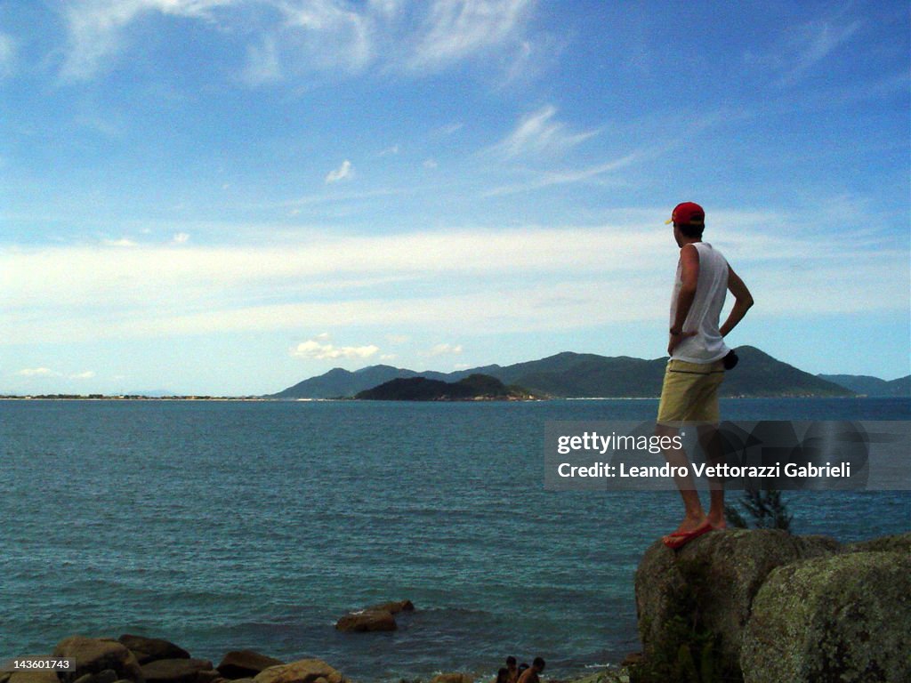 Man standing on rock at Pinheira beach