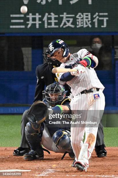 Yasutaka Shiomi of the Yakult Swallows hits a solo home run in the 3rd inning against Orix Buffaloes during the Japan Series Game One at Jingu...