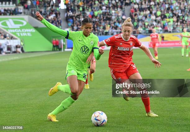 Sveindis Jane Jonsdottir of Wolfsburg is challenged by Carolin Simon of Bayern Muenchen during the FLYERALARM Women's Bundesliga match between VfL...