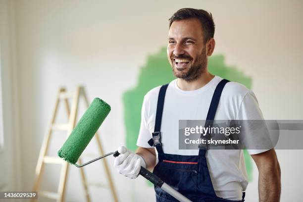 happy house painter working on home renovation process. - huisschilder stockfoto's en -beelden