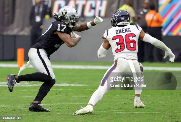 Wide receiver Davante Adams of the Las Vegas Raiders runs after a catch against safety Jonathan Owens of the Houston Texans in the second half of...