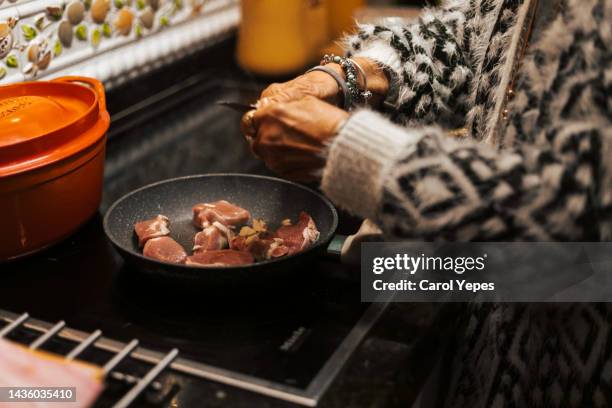 unrecognizable woman cooking some meat in her kitchen - hot latin nights stock pictures, royalty-free photos & images