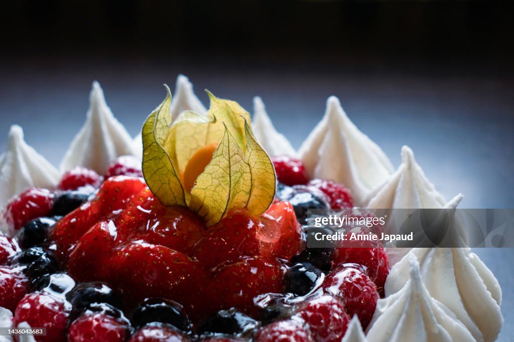 Close up, macro view of Pavlova, meringue dessert, covered with glazed fresh berries