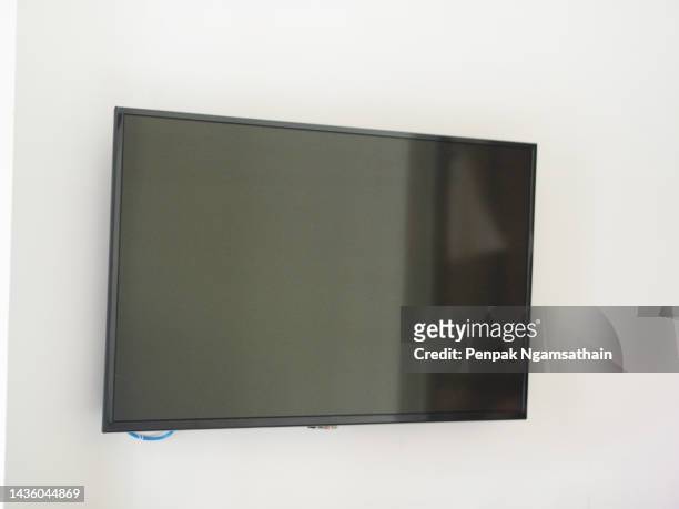 led tv hanging white wall - lcd television stockfoto's en -beelden