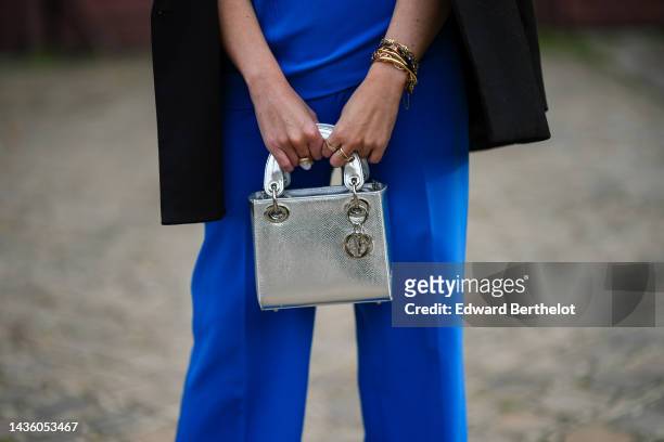 Alba Garavito Torre wears a black blazer jacket, a royal blue sleeveless / suit tank-top from Zara, matching royal blue flared suit pants, gold...