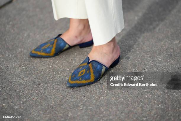 Alba Garavito Torre wears high waist white latte suit large pants, blue print pattern mules from Mimush Madrid, during a street style fashion photo...