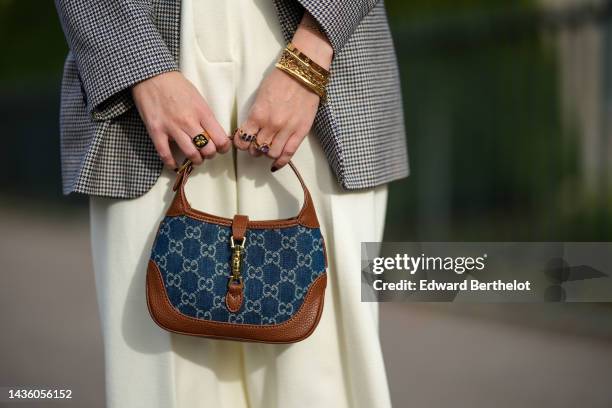 Alba Garavito Torre wears a black and white houndstooth print pattern blazer jacket, high waist white latte suit large pants, a blue GG monogram...