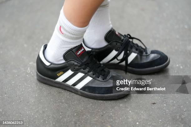 Natalia Verza wears white socks, black leather and suede Samba sneakers from Adidas, during a street style fashion photo session, on October 18, 2022...