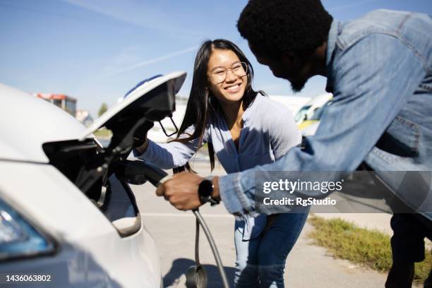 young couple on a road trip charging their electric camper - fuel efficiency stock pictures, royalty-free photos & images