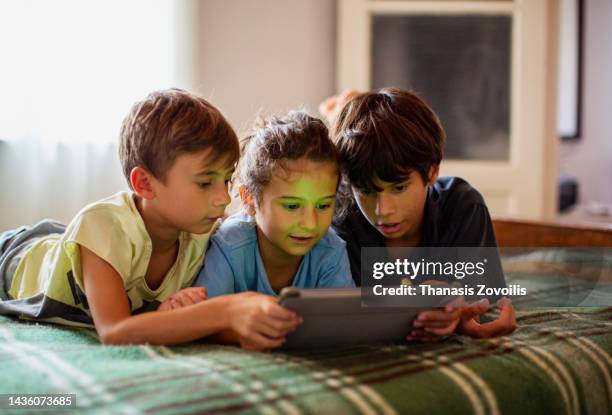 portrait of boys using a digital tablet - children on a tablet stockfoto's en -beelden