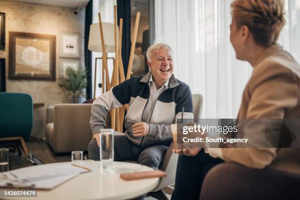 father and daughter talking about business in luxury hotel - successor stockfoto's en -beelden