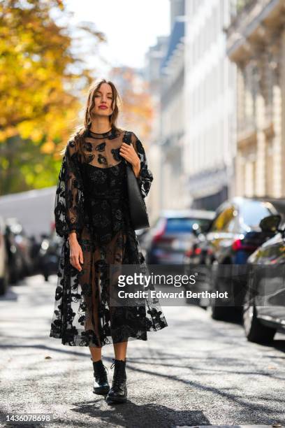 Guest wears a black tulle with embroidered fluffy leopard print pattern long sleeves / long pleated dress, a black velvet body, a black shiny leather...