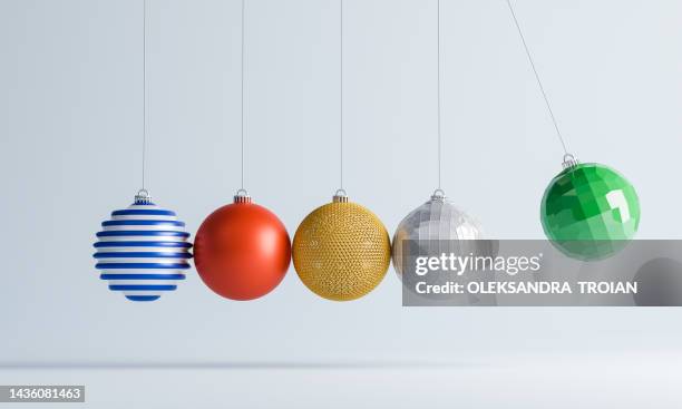 3d render of newton's cradle with christmas tree baubles - pendel stock-fotos und bilder