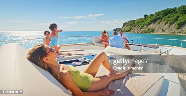 family relaxing on yacht - bare feet kneeling girl stock pictures, royalty-free photos & images