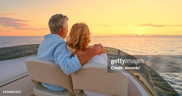 couple driving yacht - idyllic retirement stock pictures, royalty-free photos & images