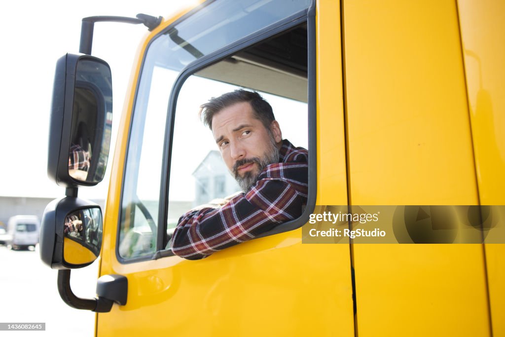 Conductor de camión mirando por encima del hombro y conduciendo hacia atrás