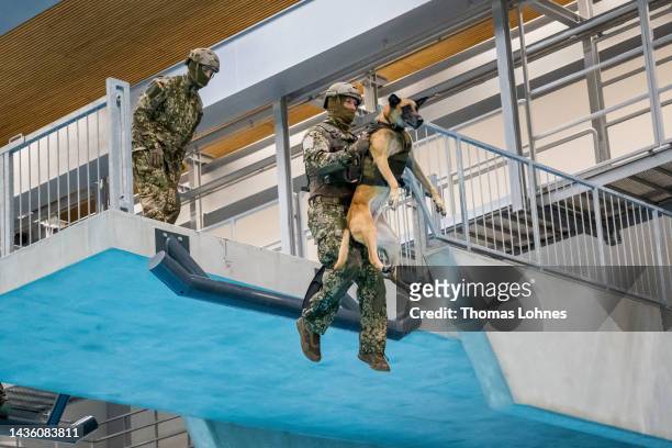 Soldier of the KSK German military special forces shows German Defense Minister Christine Lambrecht the amphibious training with the dog Marc in the...