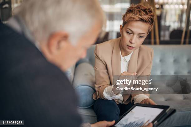 father and daughter talking about business in luxury hotel - successor stockfoto's en -beelden