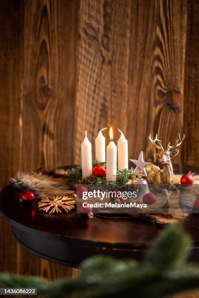 première bougie de l’avent allumée sur une couronne dans une maison rustique allemande - candle white background photos et images de collection