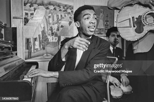 Trinidadian musician, dancer and artist Boscoe Holder playing the piano at the Institute of Contemporary Arts on Dover Street, off Piccadilly in...