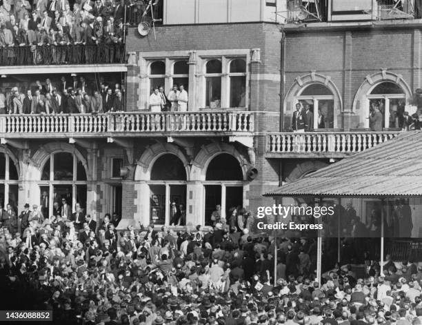 Barbadian cricketer Frank Worrell , West Indies captain, wearing a dark blazer with white trim, on the balcony of the pavilion after the West Indies...