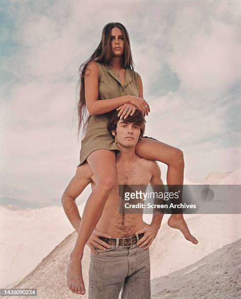 Daria Halprin sitting on shoulders of bare-chested Mark Frechette in a pose for the cult 1970 Michelangelo Antonioni film, 'Zabriskie Point'. .