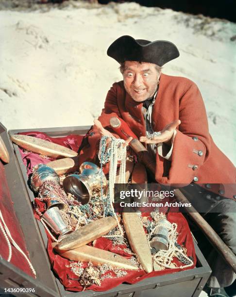 Robert Newton as Long John Silver opening treasure chest in 'Treasure Island'. .