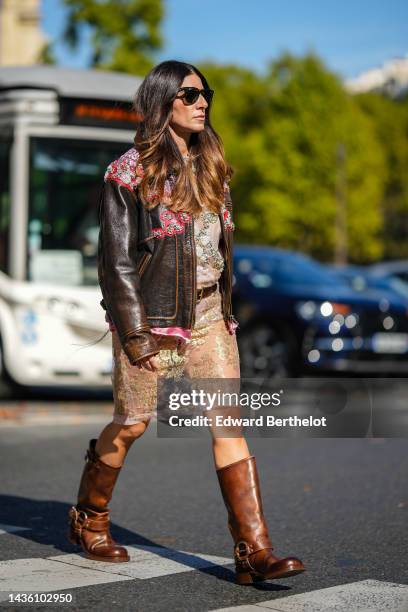 Guest wears black sunglasses from Ray Ban, a dark brown shiny leather with embroidered red leather / silver and pink crystal print pattern zipper...