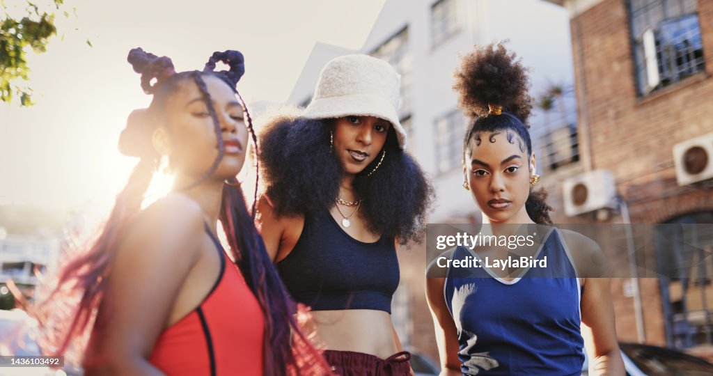 Black women, street style and fashion hairstyle with friends standing outside in urban city or ghetto looking trendy and fierce. Portrait of stylish females showing beauty and attitude in Atlanta