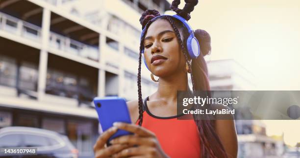 smartphone, headphones and black woman in city for outdoor 5g networking and listening to music or youth podcast. gen z, urban girl walking on cellphone, audio app technology and social media online - z com stock pictures, royalty-free photos & images