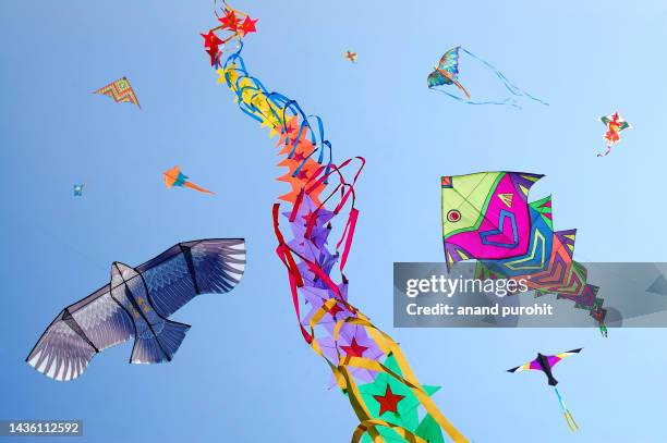 kites flying in clear blue sky, india - stock photo - religiöses fest stock-fotos und bilder