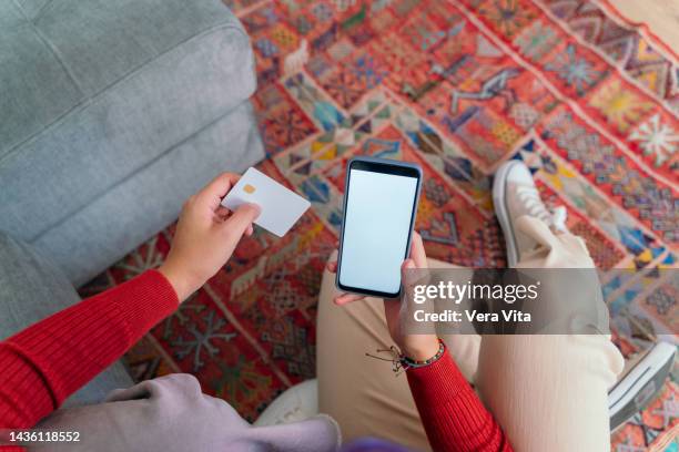 close up of hands holding phone and online payment isolated on red carpet. - credit card mockup stock pictures, royalty-free photos & images