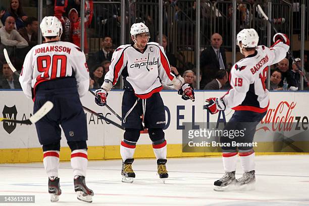 Alex Ovechkin of the Washington Capitals celebrates with teammates Marcus Johansson and Nicklas Backstrom after Ovechkin scored a goal to give the...