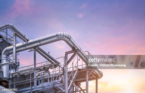 steel pipelines and beautiful sky at industrial zone - petrochemie stock-fotos und bilder