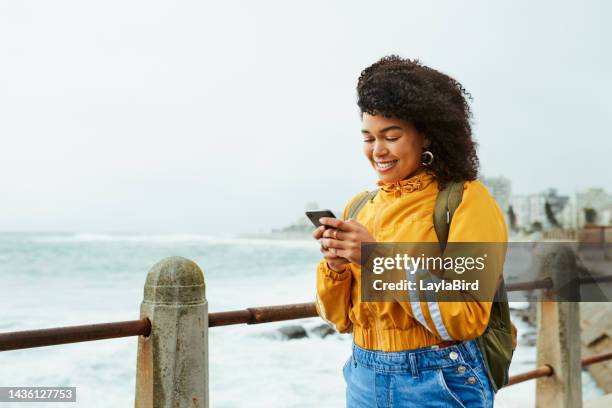 strand, telefon und glückliche frau, die e-mails tippt, einen blog liest und im internet surft. glück, lächeln und mädchen aus puerto rico scrollen in den sozialen medien mit einem smartphone in der natur am meer - travel real people water stock-fotos und bilder