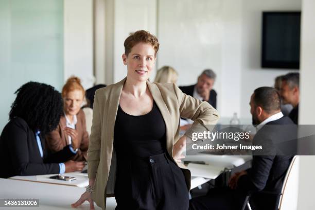 smiling businesswoman in boardroom - 40 50 business woman stock pictures, royalty-free photos & images