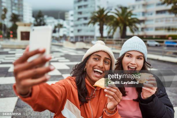 selfie, pizza e amici con donne che scattano una fotografia su un telefono all'aperto in città durante l'inverno. fast food, felice e mangiare con una giovane donna e amica fuori in città su uno sfondo urbano - real people foto e immagini stock