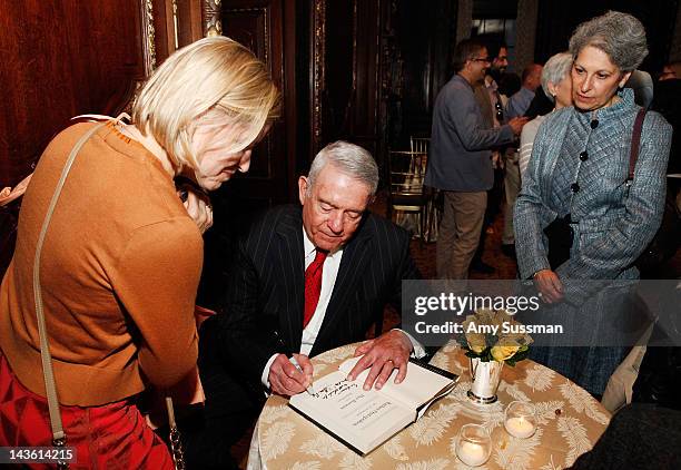 Dan Rather signs a copy of his book "Rather Outspoken: My Life In The News" at the Drawing Room at the New York Palace Hotel on April 30, 2012 in New...