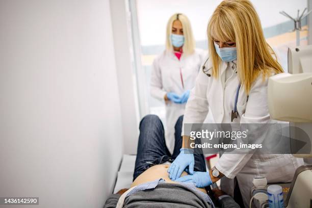 doctor examining her patient in medical office - appendix stock pictures, royalty-free photos & images