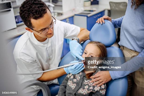 brave girl at the dentist's appointment - pediatric dentistry stock pictures, royalty-free photos & images