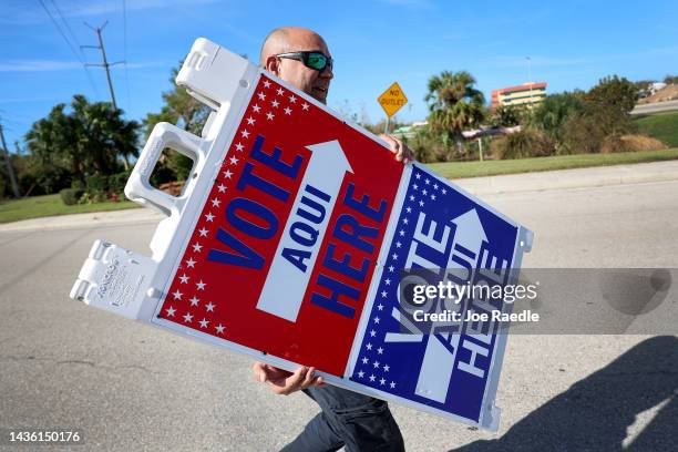 Jene Hinspeter, a Lee County Election official, sets up signs directing voters to the polling station at Wa-Ke Hatchee park on October 24, 2022 in...