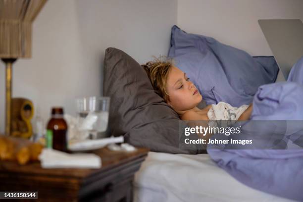 sick boy lying in bed - bedside table kid asleep stock pictures, royalty-free photos & images